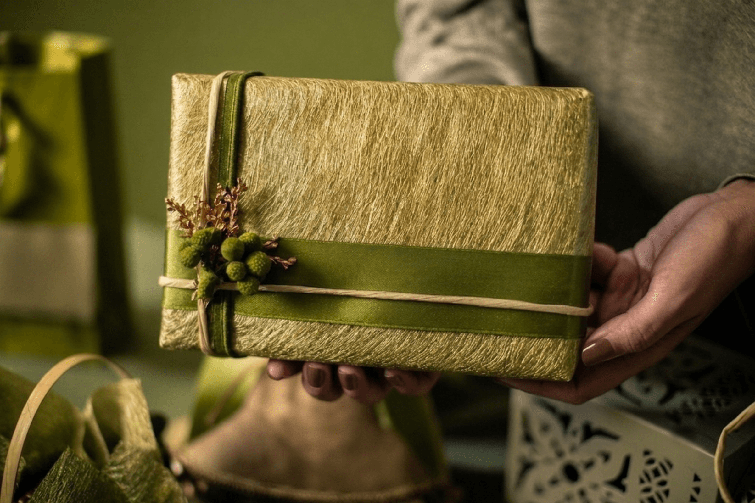 A woman holding a thoughtfully wrapped gift outdoors